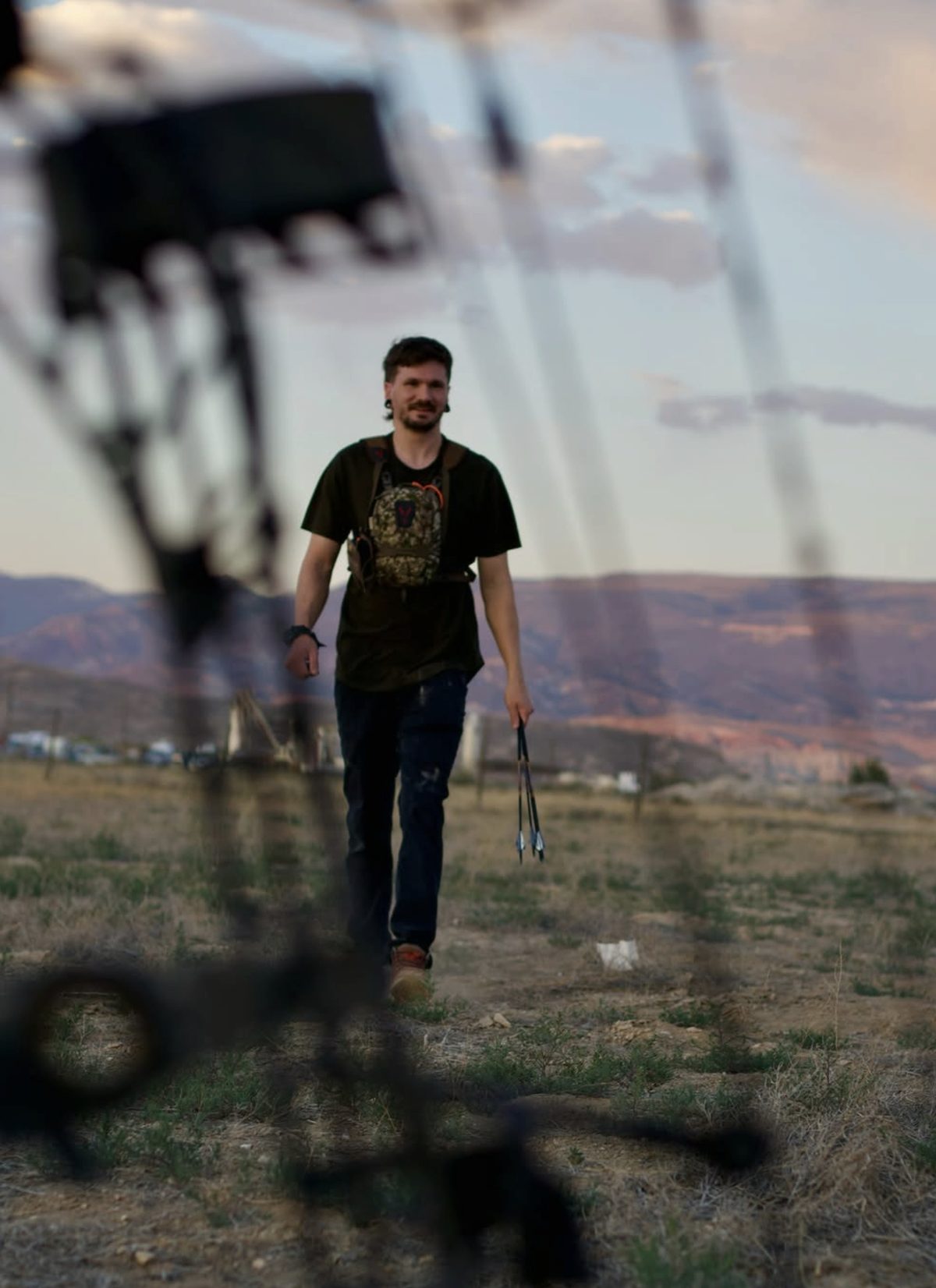 Skyler walking back across a field with arrows in hand